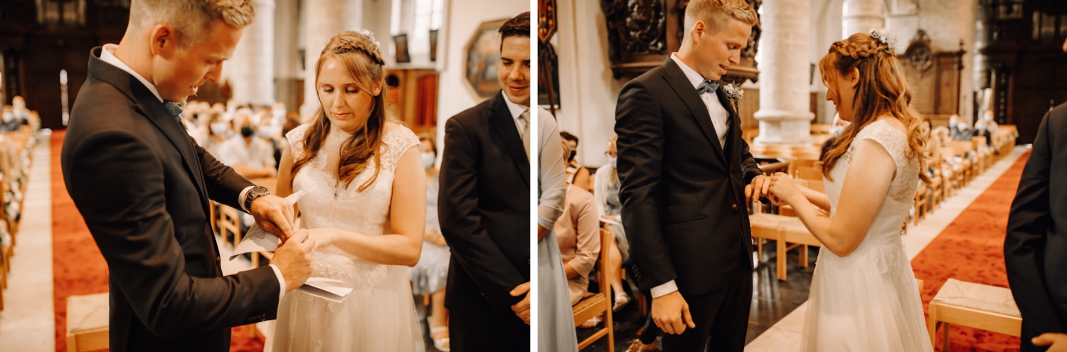bruid en bruidegom geven elkaar de ringen tijdens huwelijksviering in de kerk te belsele