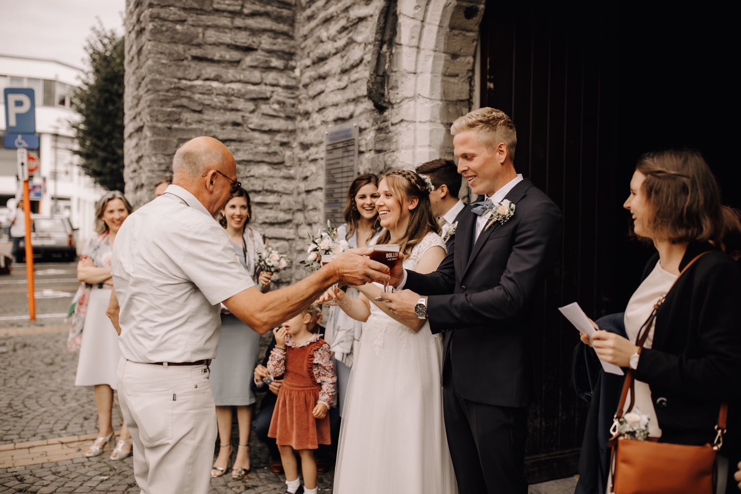 bruid en bruidegom ontvangen een biertje aan de kerk te belsele