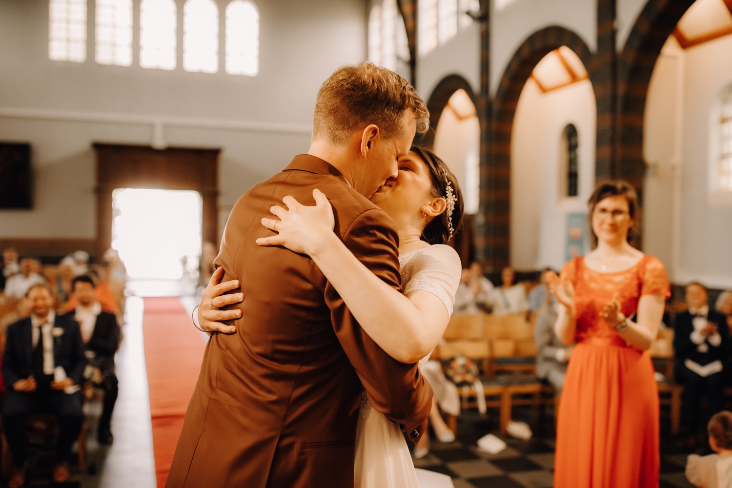bruid en bruidegom kussen in de kerk van Edegem