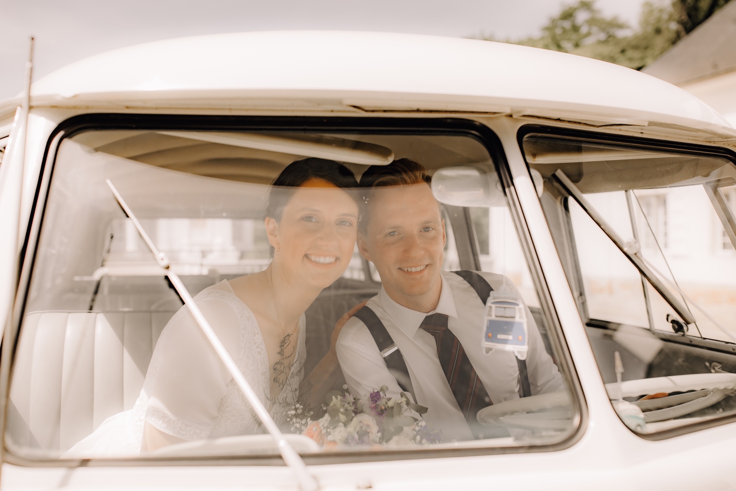 bruidspaar poseert tijdens fotoshoot in volkswagen busje