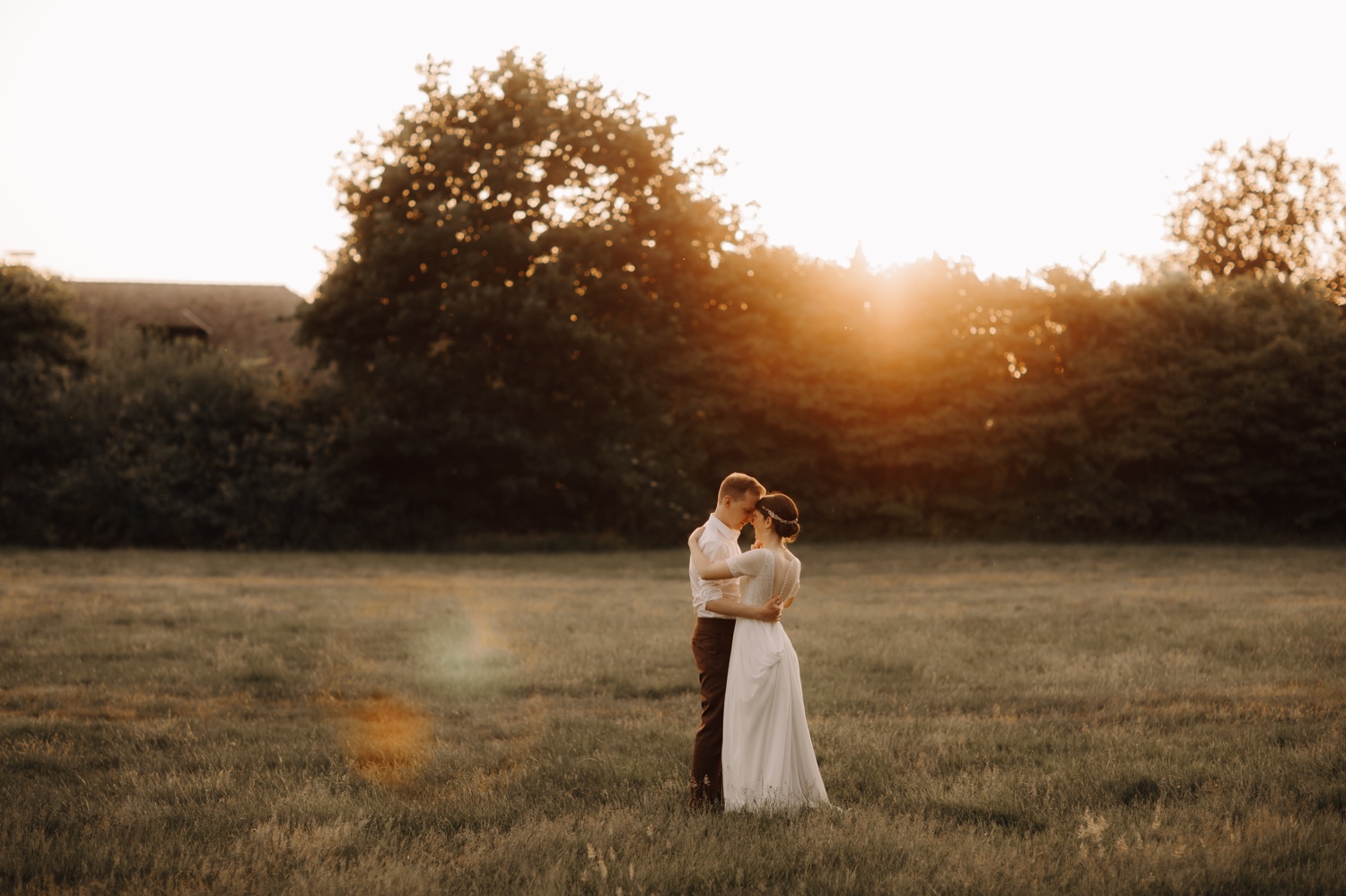 bruidspaar danst in veld tijdens zonsondergang te Edegem
