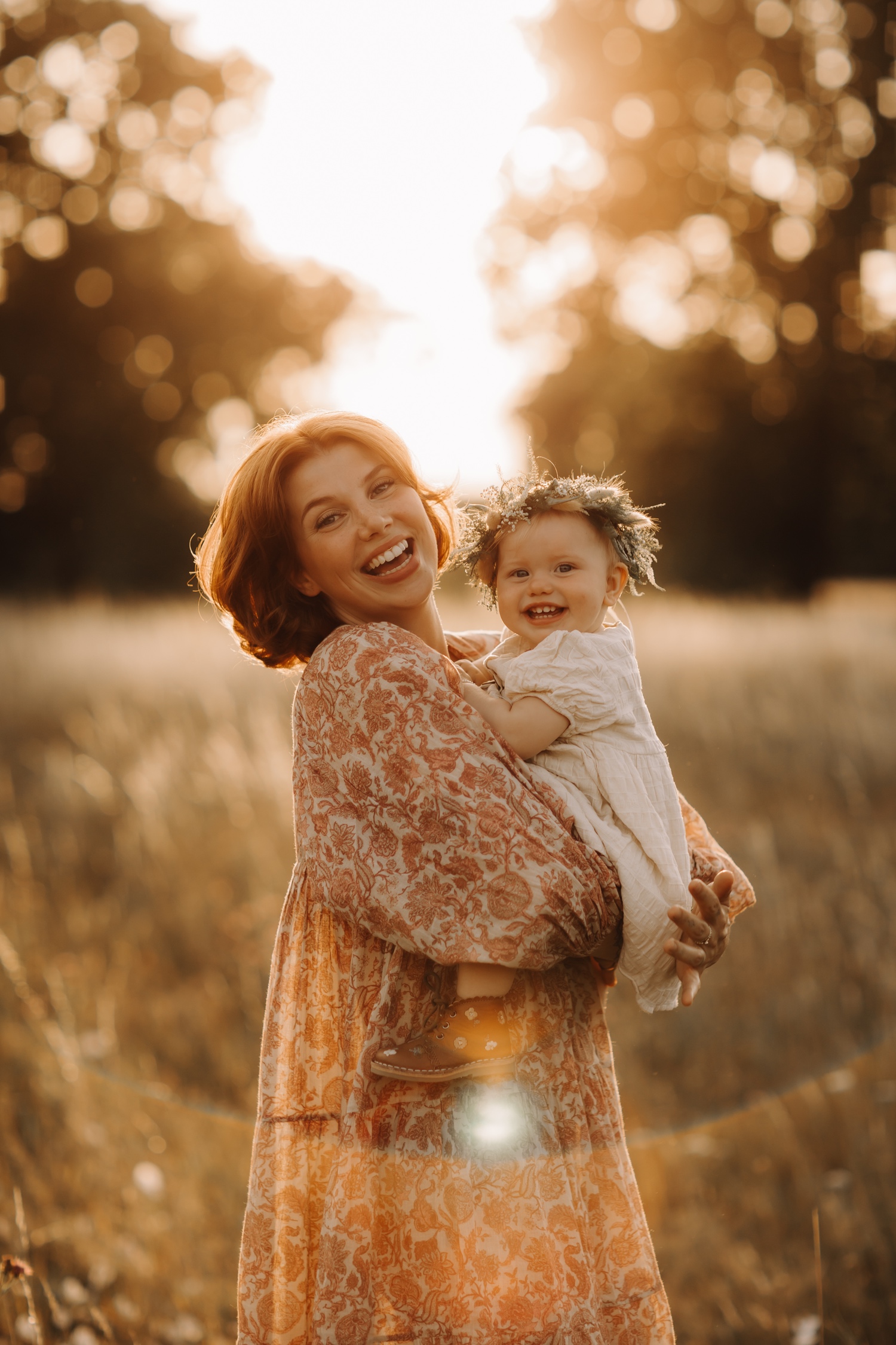 mama en dochter lachen naar de camera tijdens fotoshoot bij zonsondergang in Lommel