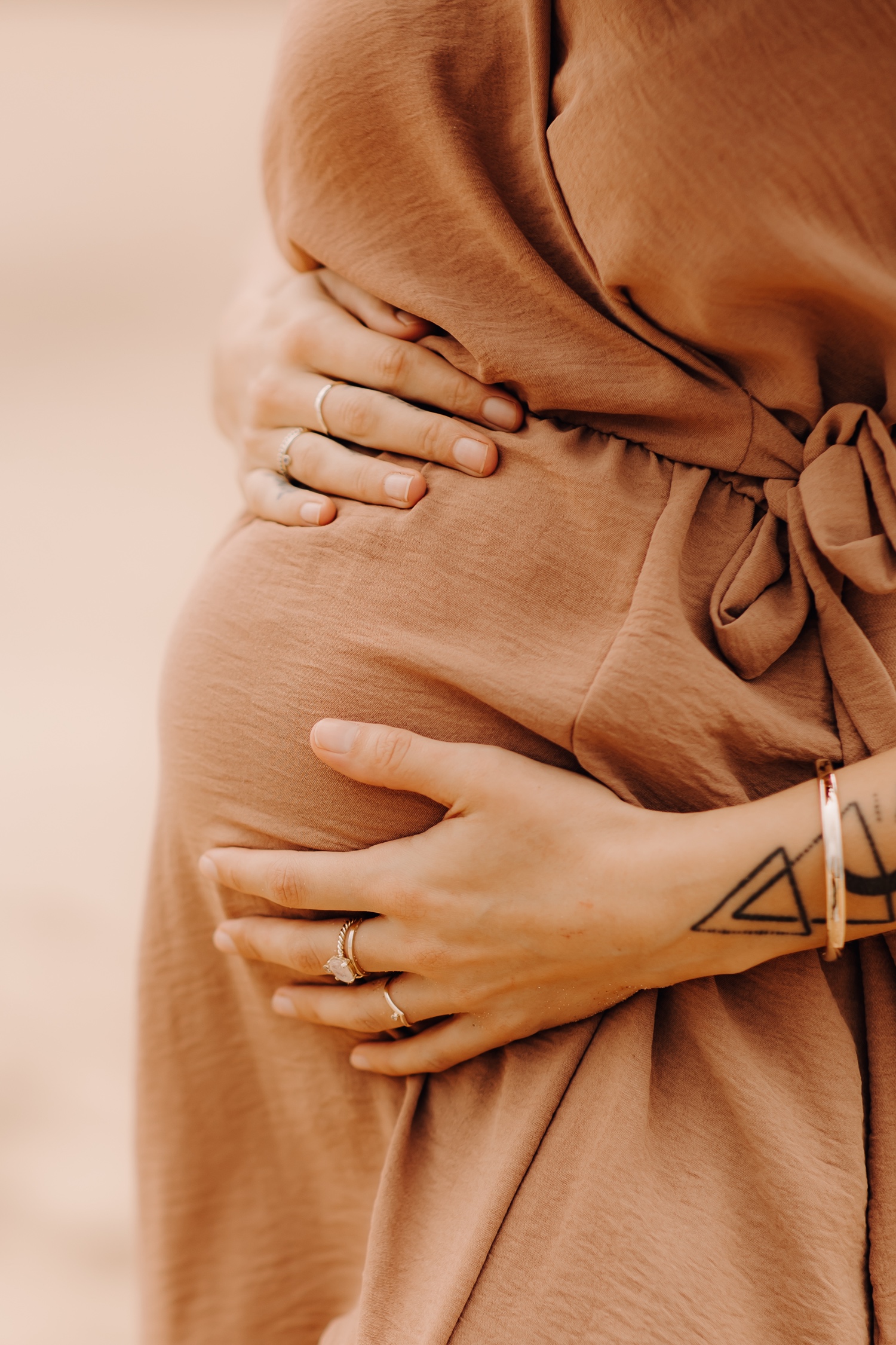 zwangerschapsfotograaf limburg - close-up van de zwangere buik op het strand van Praia da bordeira in Portugal