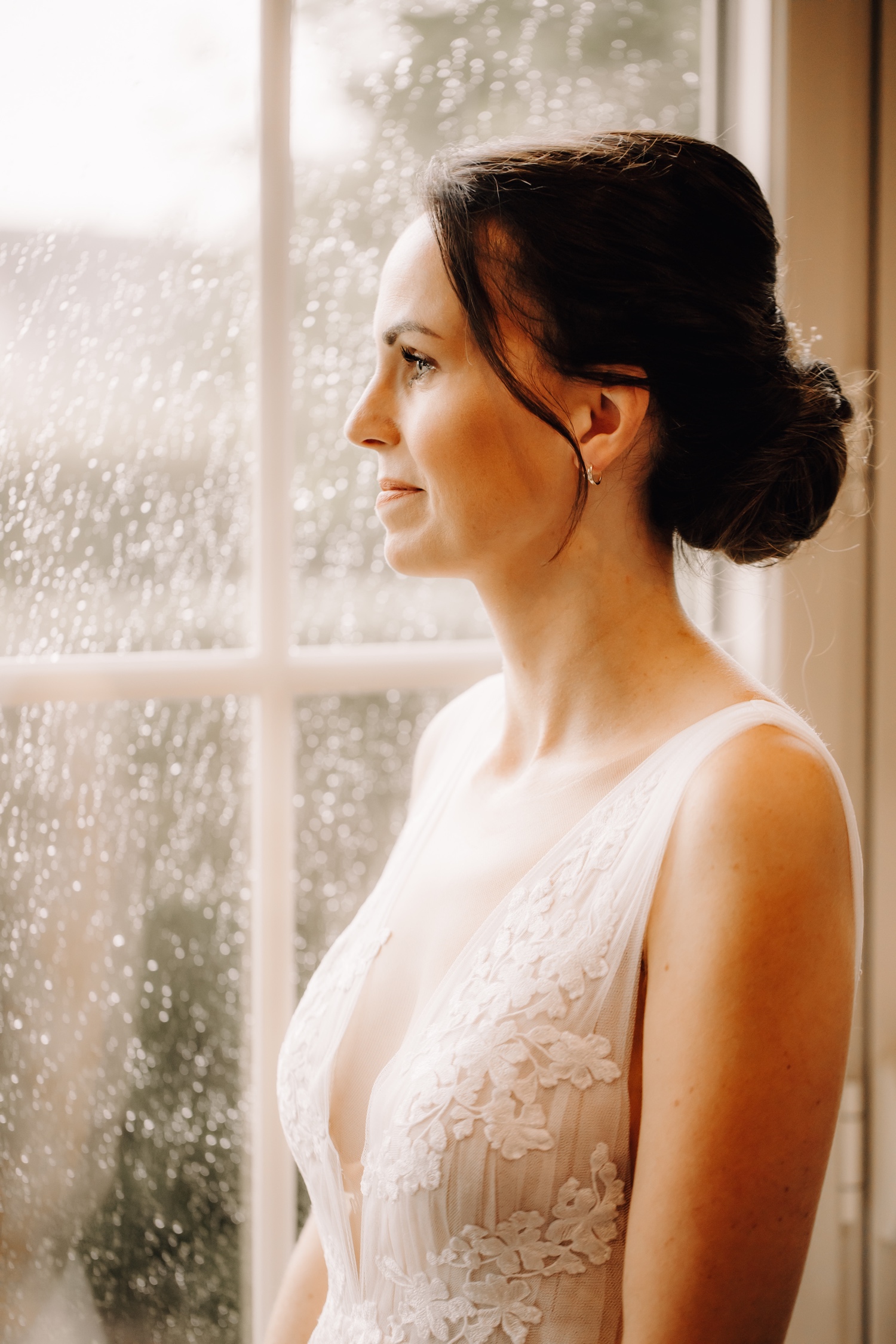Huwelijksfotograaf Limburg - portret van de bruid aan het raam