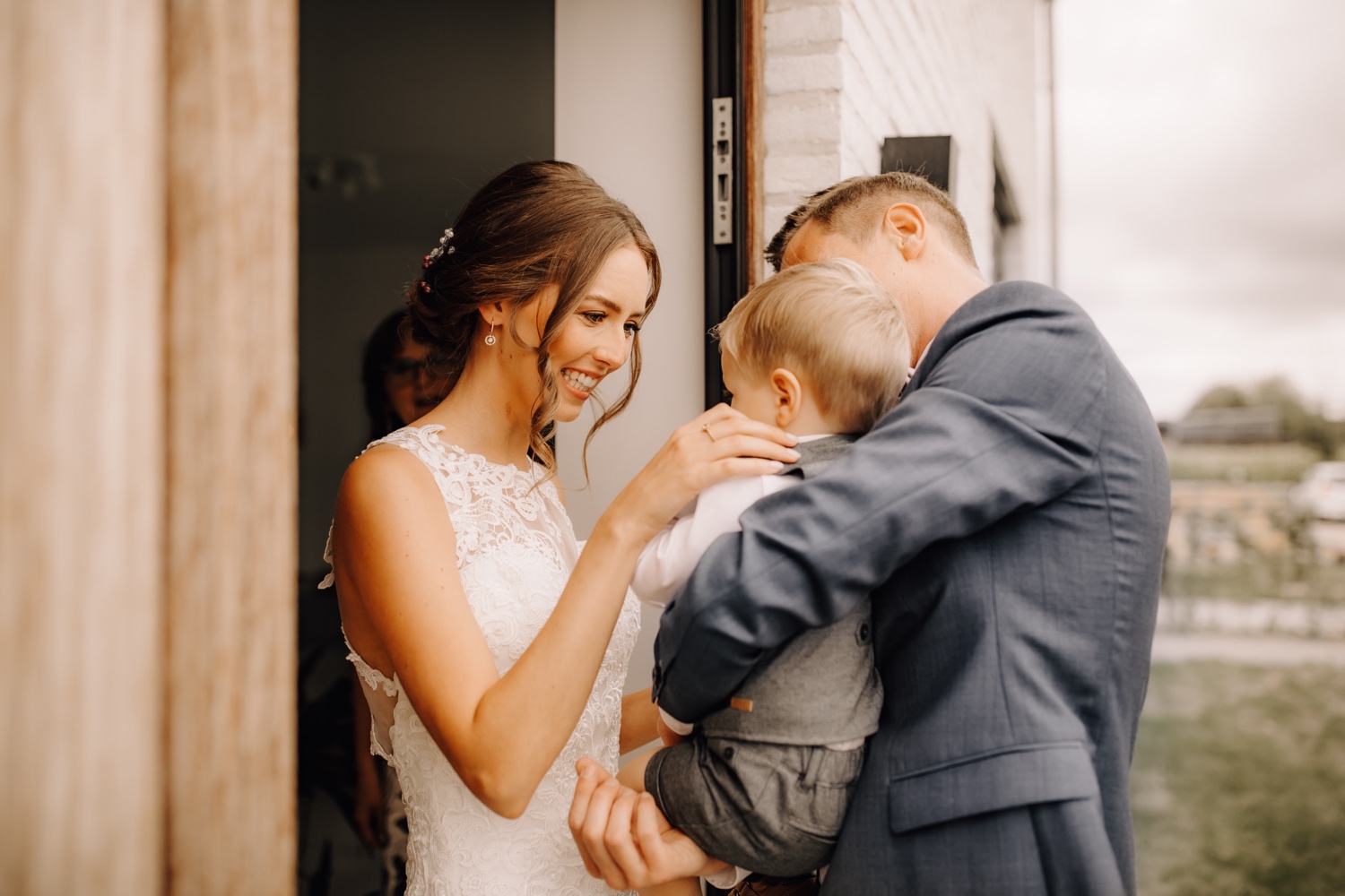 Huwelijksfotograaf limburg - bruid is geëmotioneerd bij het zien van haar bruidegom en hun zoontje