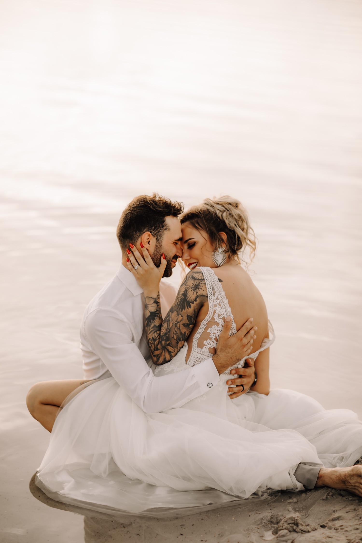 Huwelijksfotograaf Limburg - bruidspaar gaat in water zitten bij fotoshoot