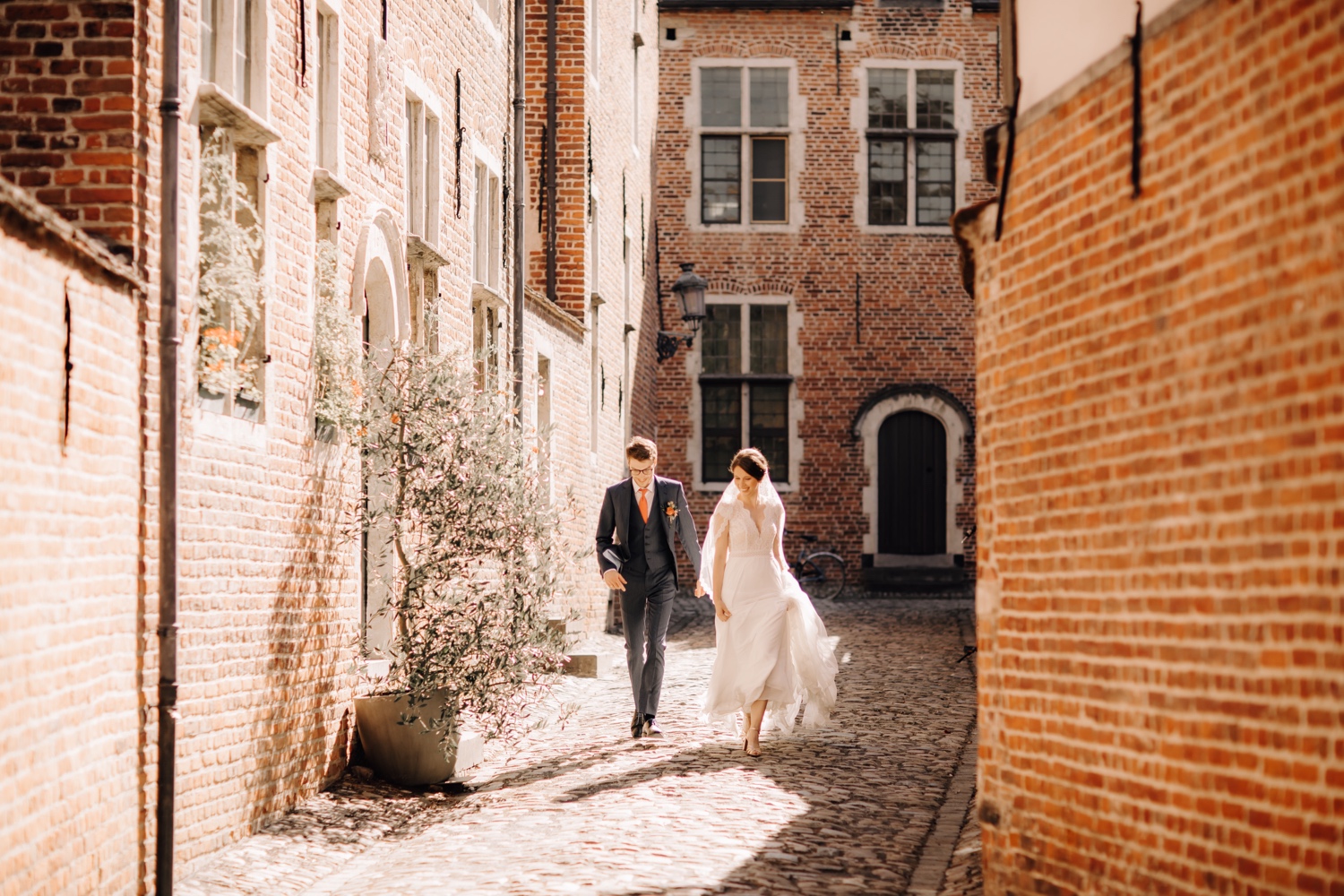 Huwelijksfotograaf Limburg - bruidspaar loopt door de straten van het begijnhof te Leuven