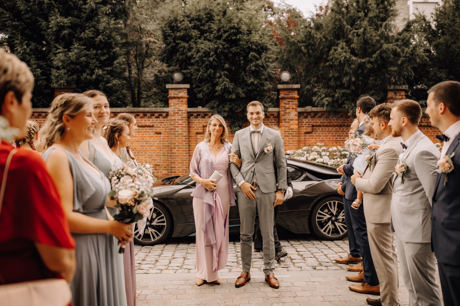 Huwelijksfotograaf Limburg - bruidegom maakt intrede in kerk met zijn moeder