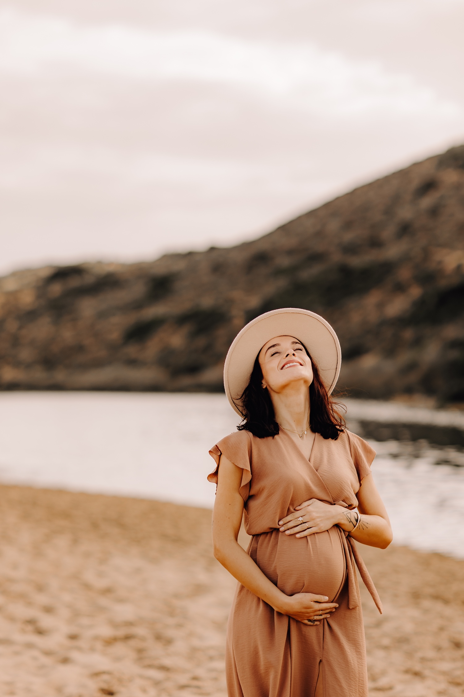 zwangerschapsfotograaf limburg - zwangere dame geniet van de laatste zonnestralen op Praia da bordeira