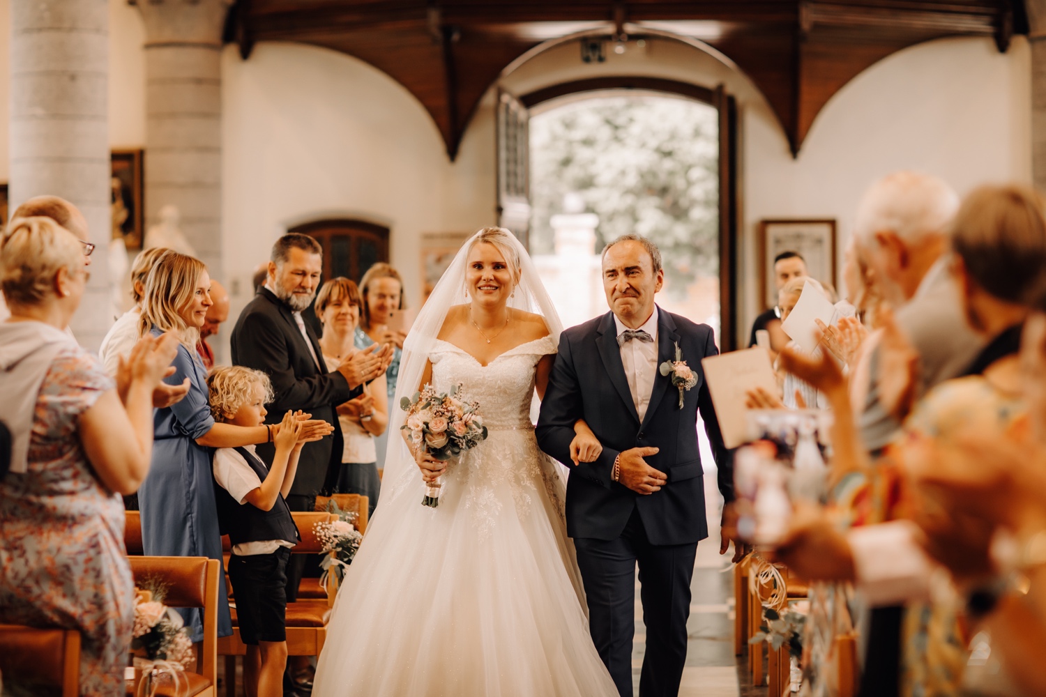 Huwelijksfotograaf Limburg - bruid maakt haar intrede in de kerk met haar vader