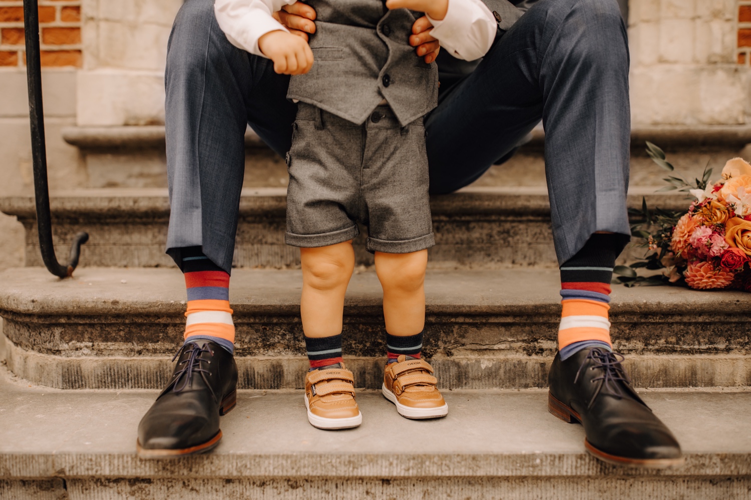 Huwelijksfotograaf limburg - bruidegom en zoontje tonen hun matching sokken