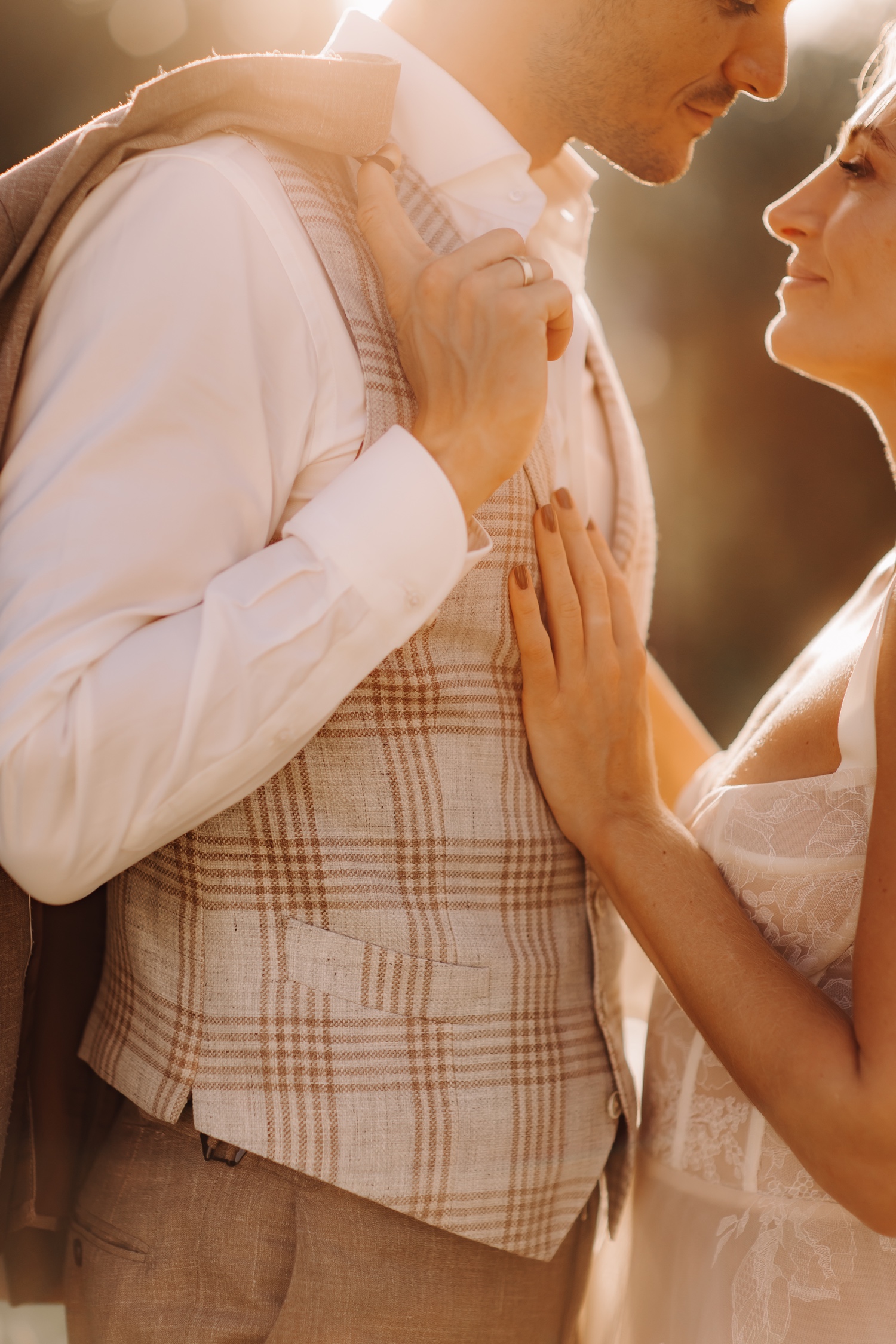 Huwelijksfotograaf buitenland - bruid legt haar hand op de borstkast van de bruidegom tijdens zonsondergang