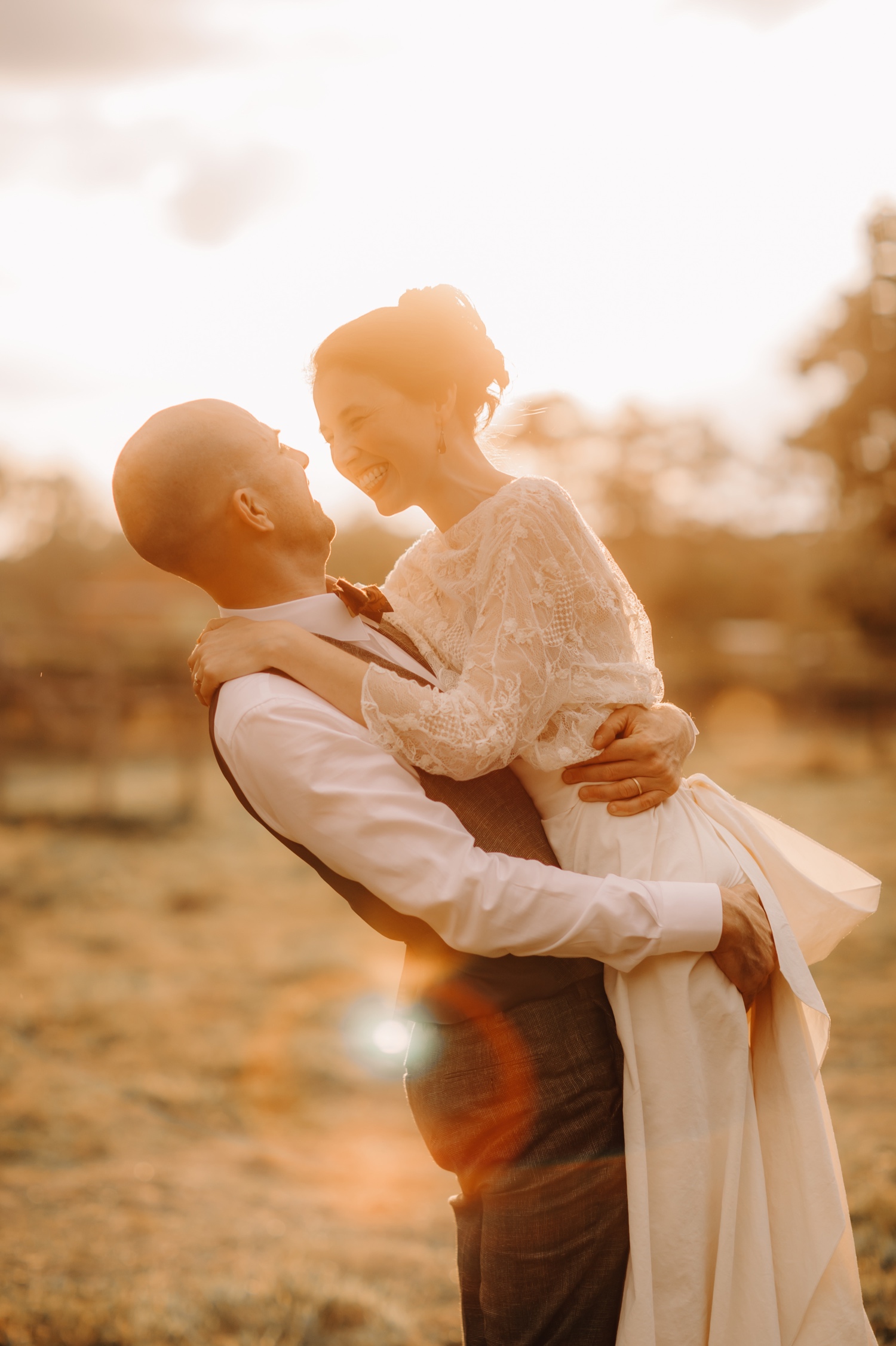 Huwelijksfotograaf Limburg - bruidspaar knuffelt elkaar stevig tijdens zonsondergang