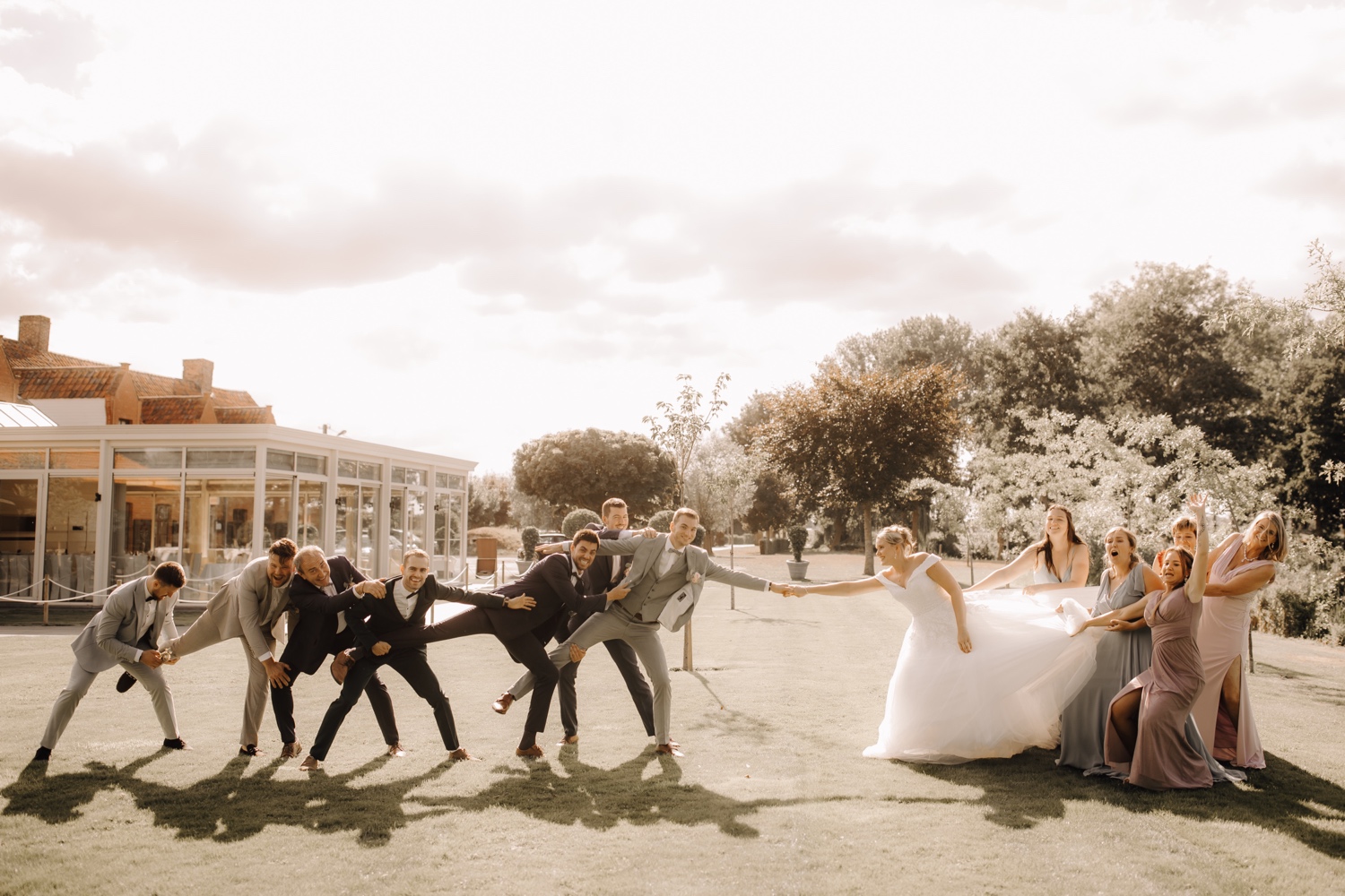 Huwelijksfotograaf Limburg - ludieke groepsfoto's in de tuin van feestzaal de zandberg