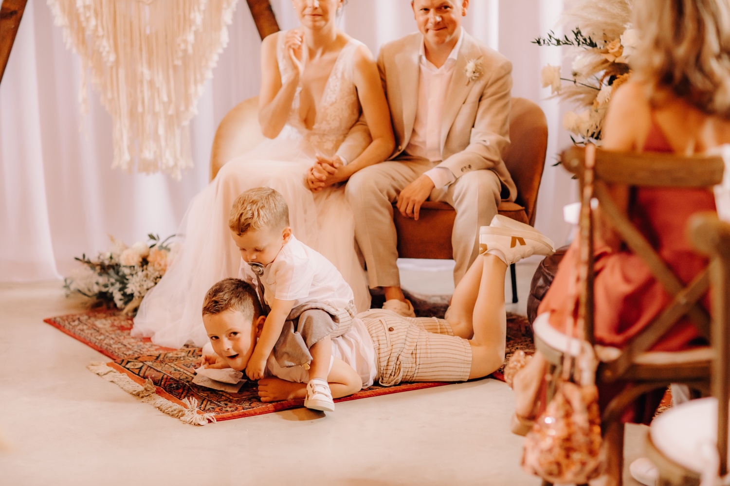 Huwelijksfotograaf Limburg - kleine broer gaat bovenop grote broer zitten tijdens ceremonie