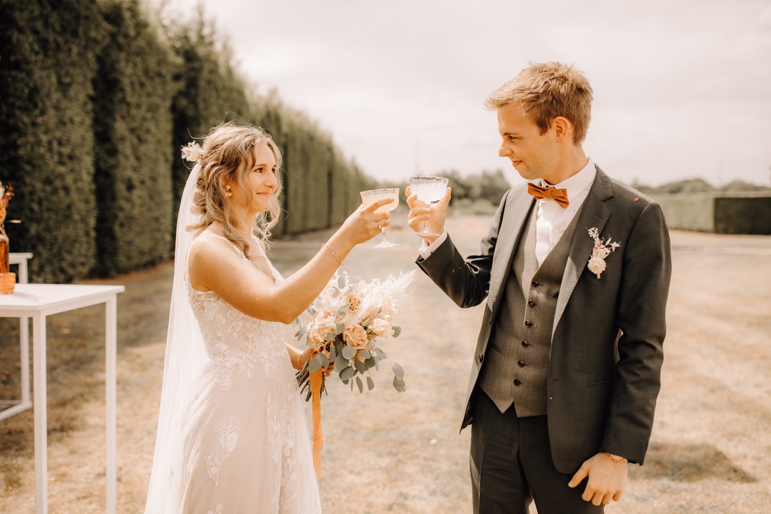 Huwelijksfotograaf Limburg - bruidspaar klinkt het glas met elkaar
