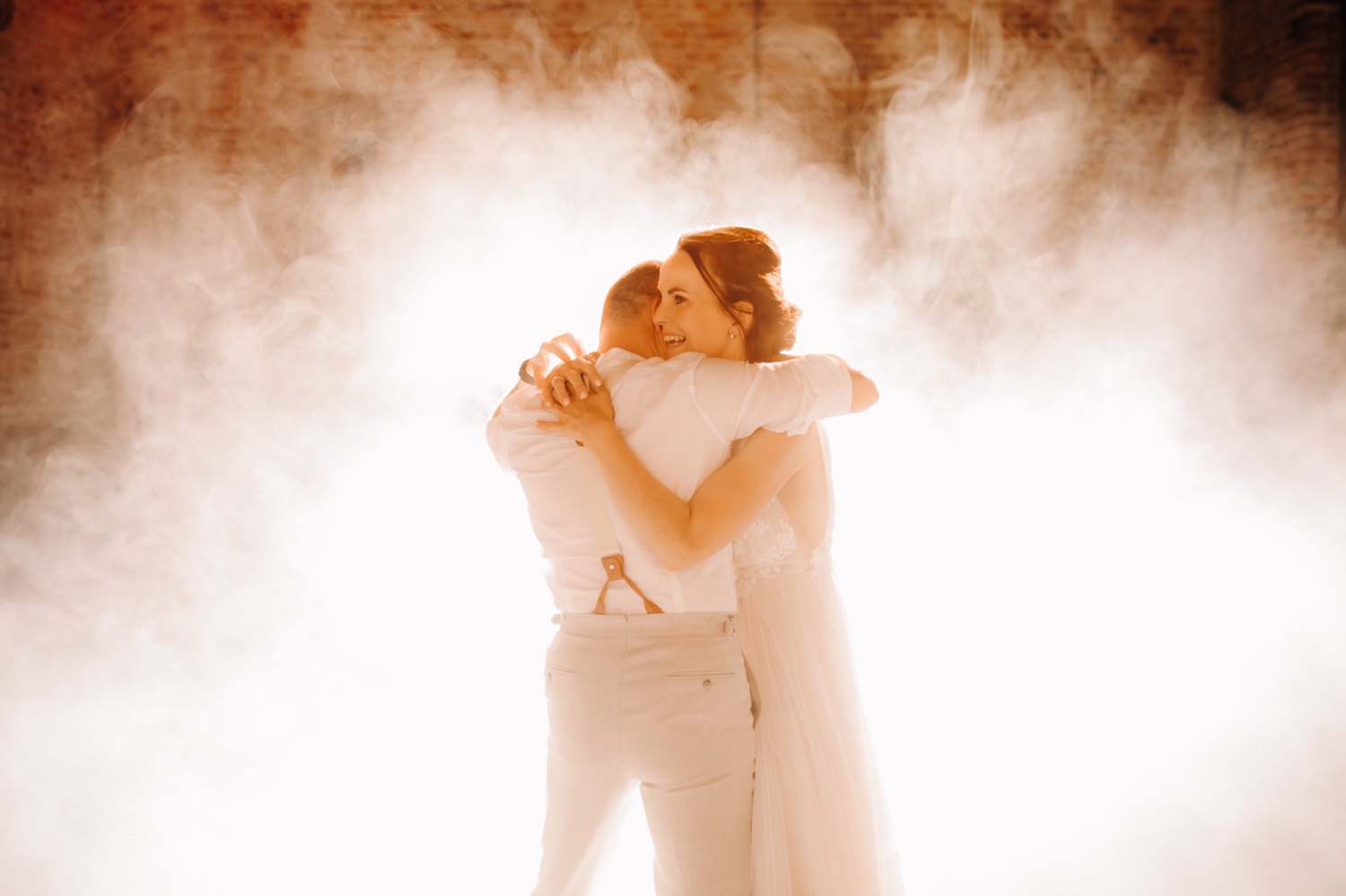 Huwelijksfotograaf Limburg - bruidspaar verdwijnt in de rook tijdens openingsdans