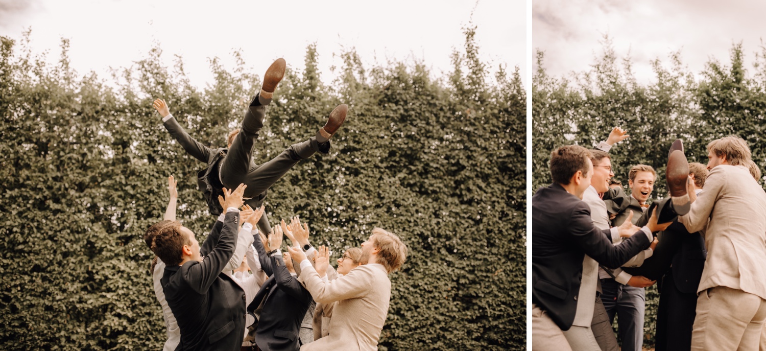 Huwelijksfotograaf Limburg - bruidegom wordt in de lucht gesmeten door bruidsjonkers