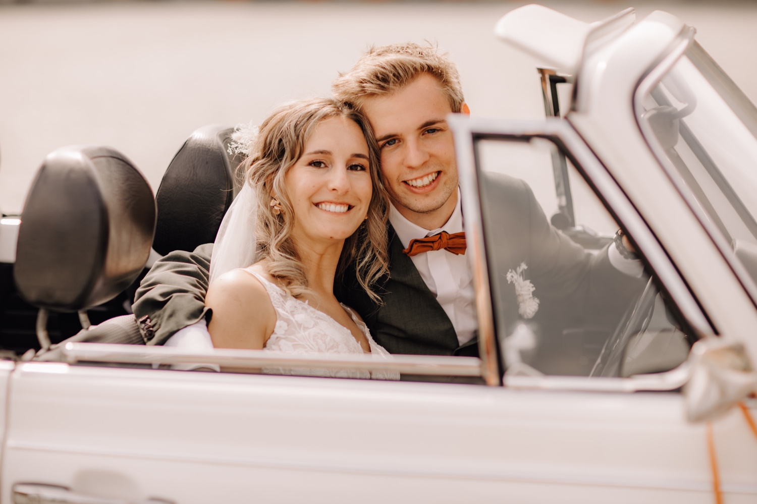 Huwelijksfotograaf Limburg - bruidspaar poseert in volkswagen kever