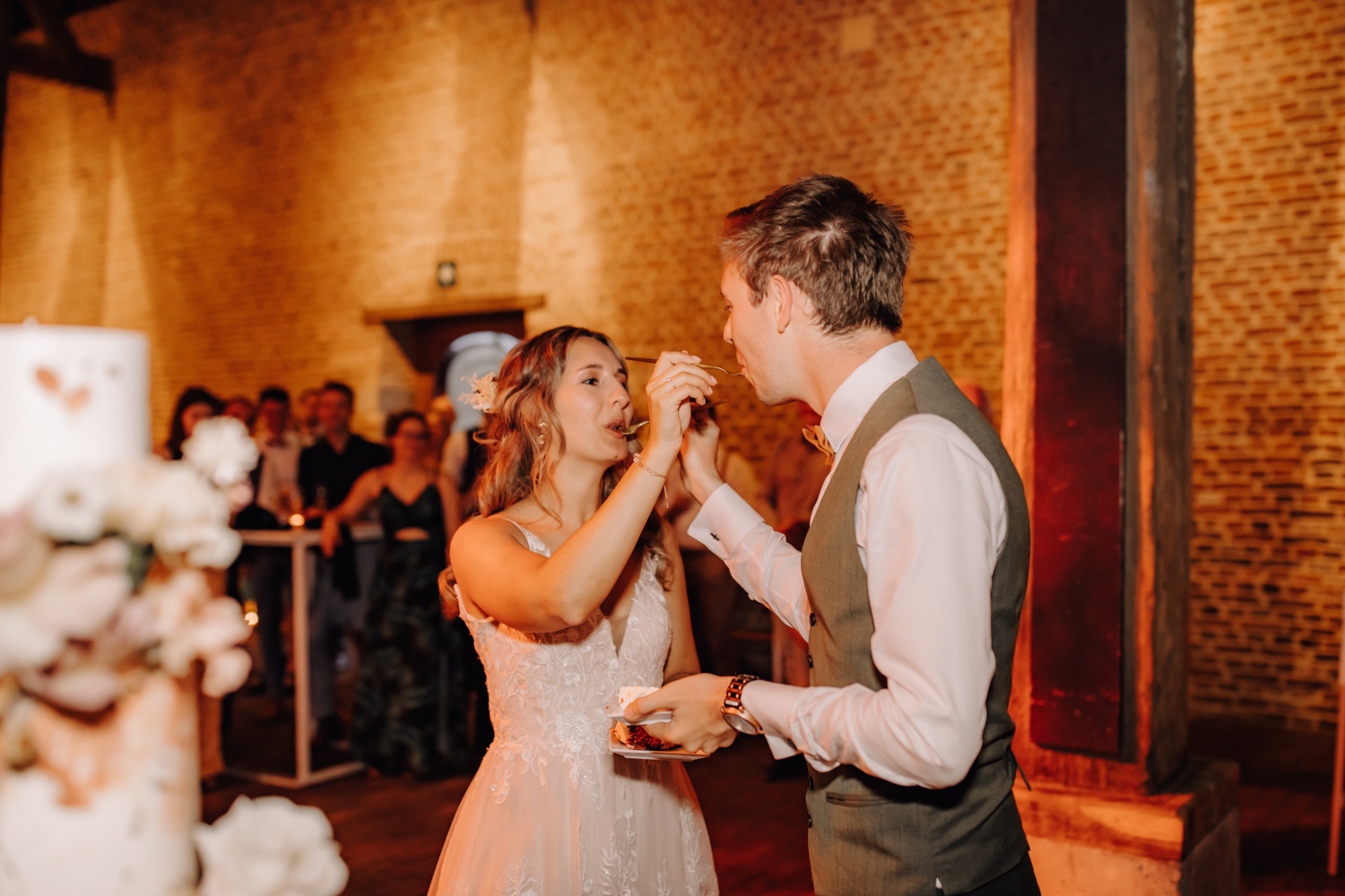Huwelijksfotograaf Limburg - bruidspaar geeft elkaar hapje van de taart