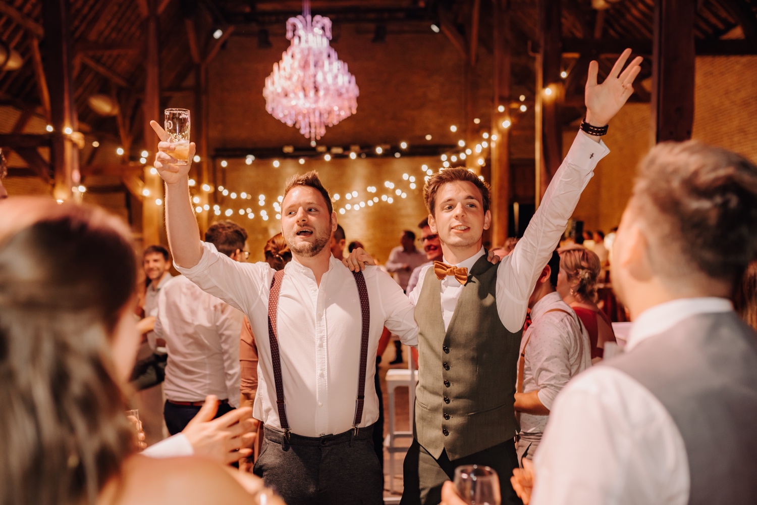 Huwelijksfotograaf Limburg - bruidegom en bruidsjonker steken armen in de lucht