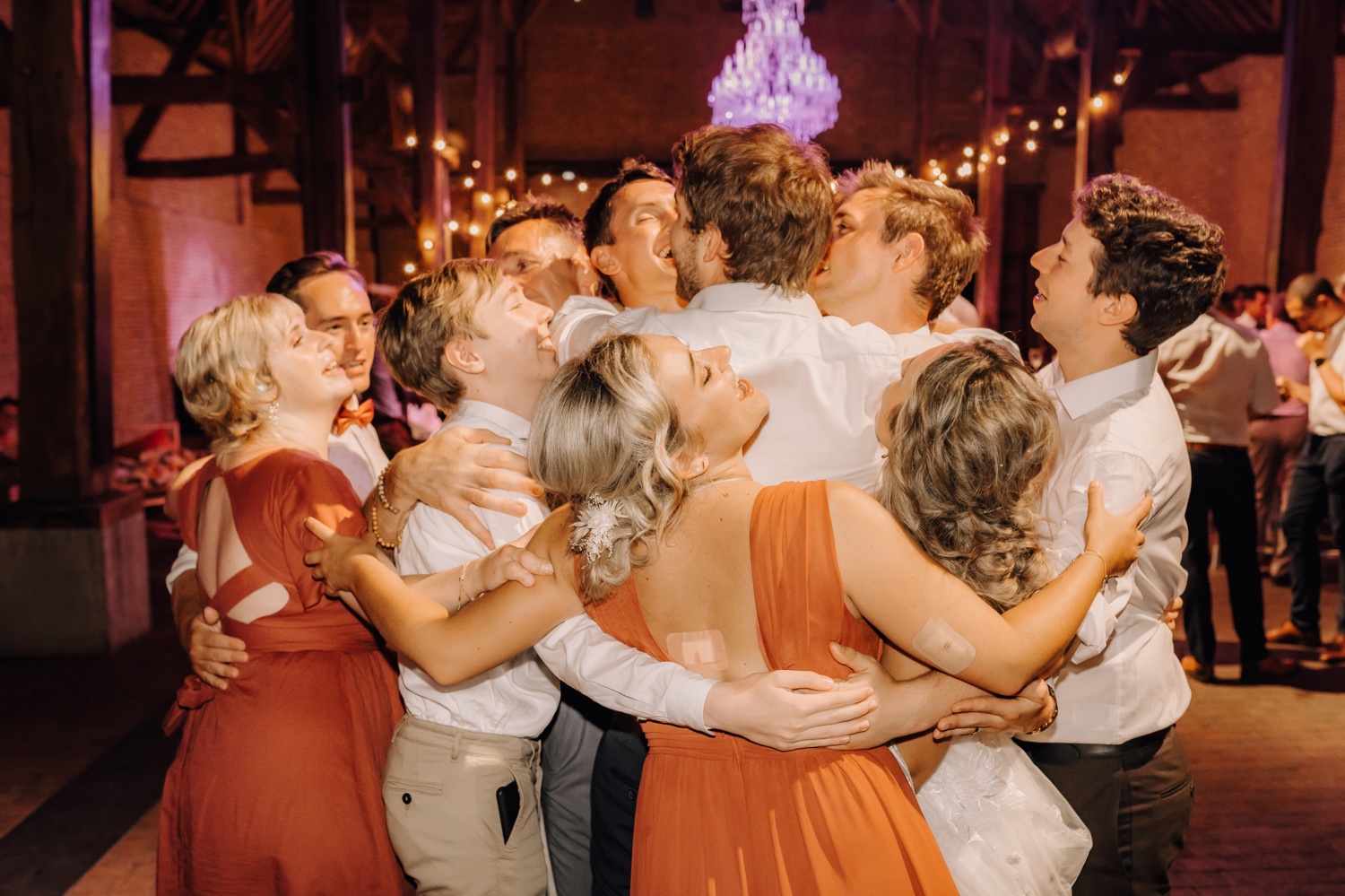 Huwelijksfotograaf Limburg - groepsknuffel op de dansvloer
