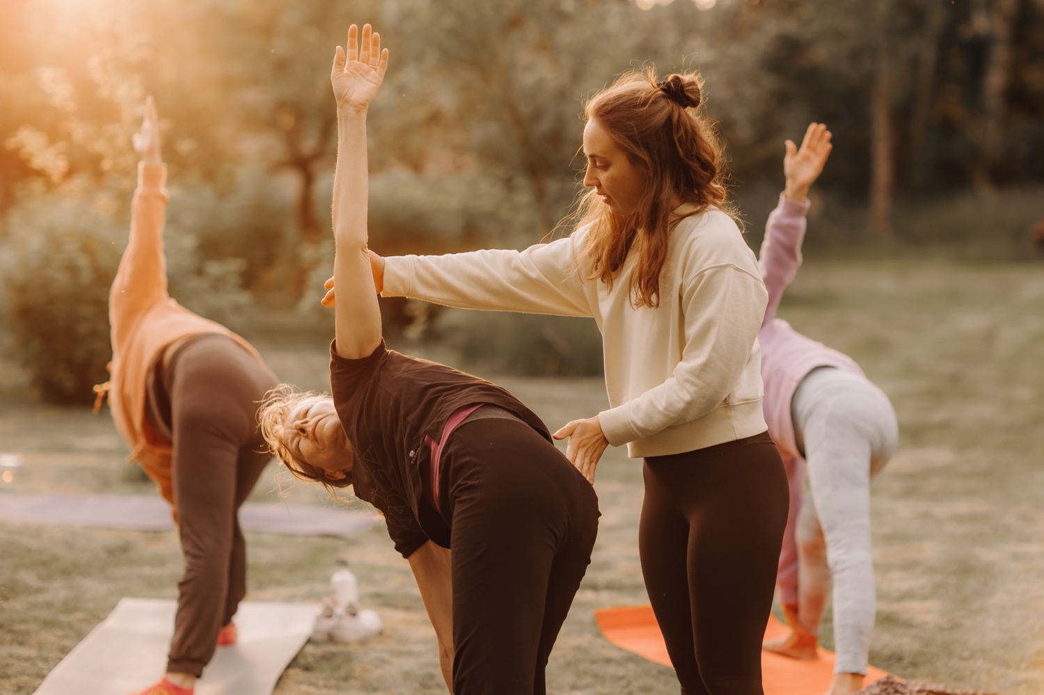 Studio medisana - yoga instructrice helpt de leerlingen met de juiste houding
