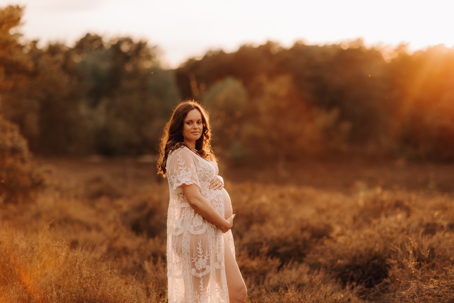 gezinsfotograaf Limburg - fotosessie van zwangere vrouw bij zonsondergang in Zonhoven