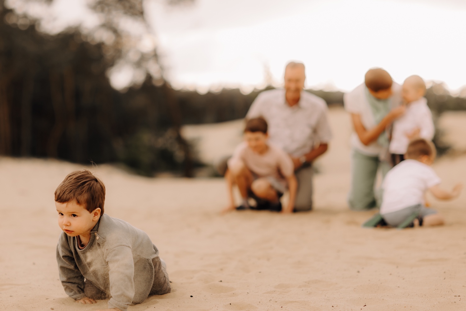gezinsfotograaf Limburg - kleinkind probeert weg te kruipen voor de groepsfoto