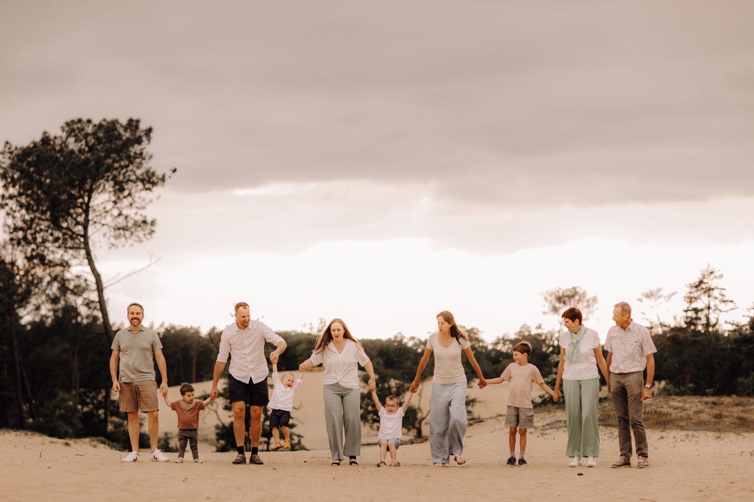 gezinsfotograaf Limburg - de hele familie wandelt door het zand in Hechtel