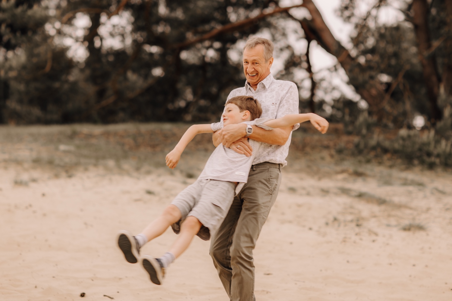 gezinsfotograaf Limburg - grootvader zwiert met kleinkind in het rond