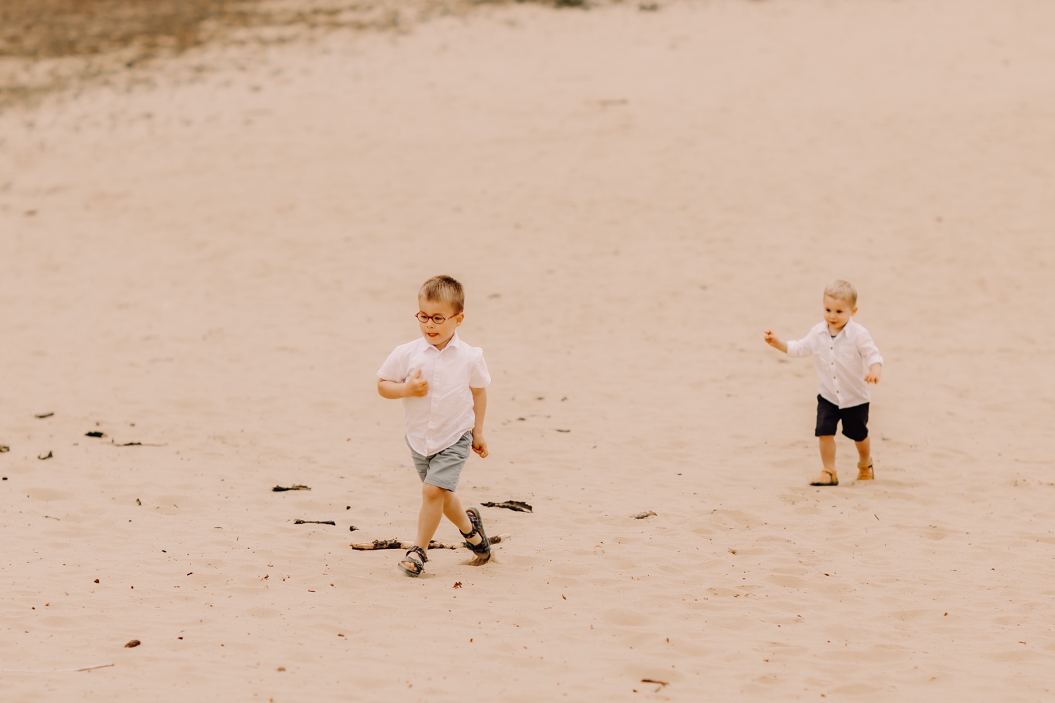 gezinsfotograaf Limburg - kleinkinderen lopen in het zand te Hechtel