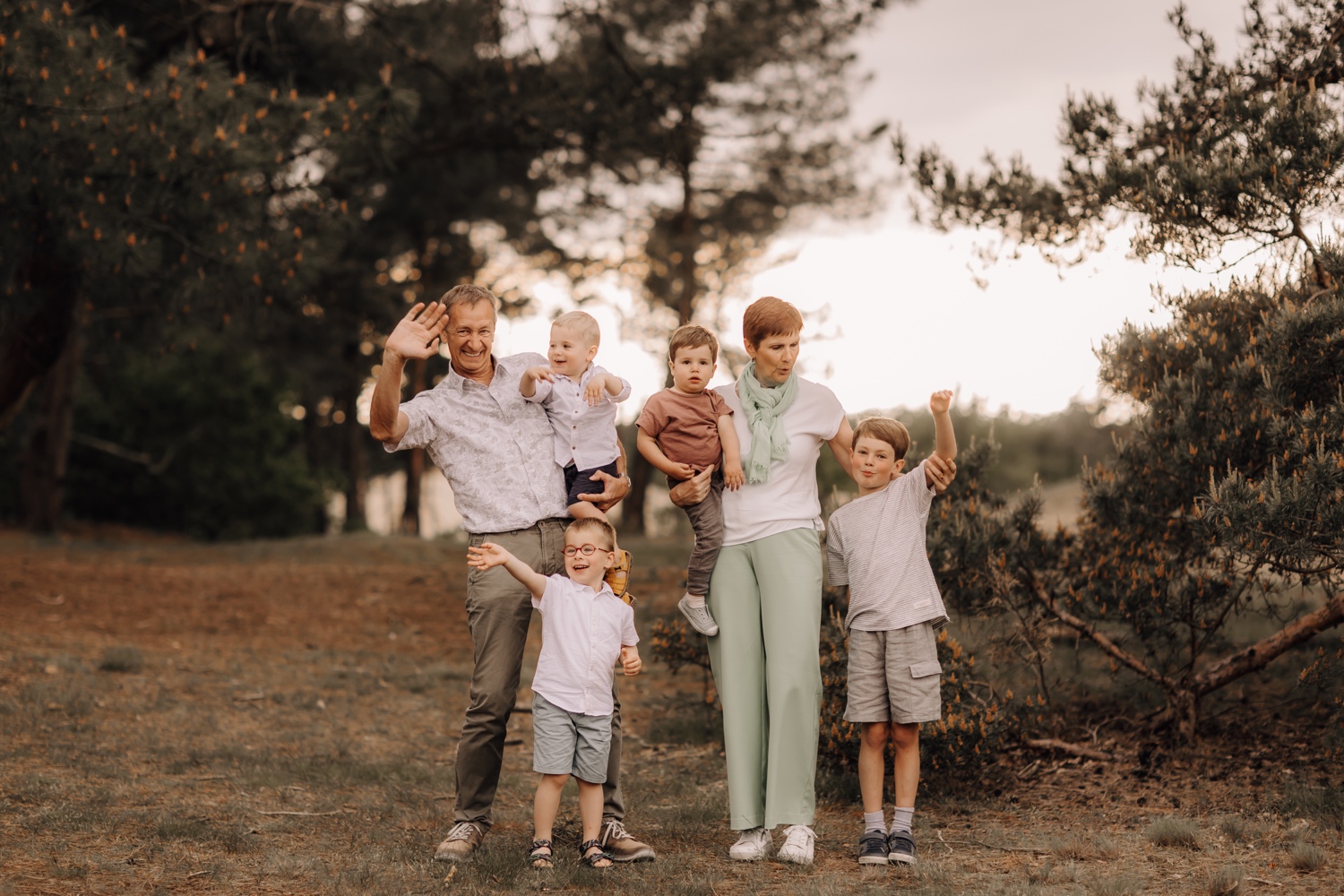 gezinsfotograaf Limburg - grootouders poseren met de kleinkinderen tussen de bomen in Hechtel
