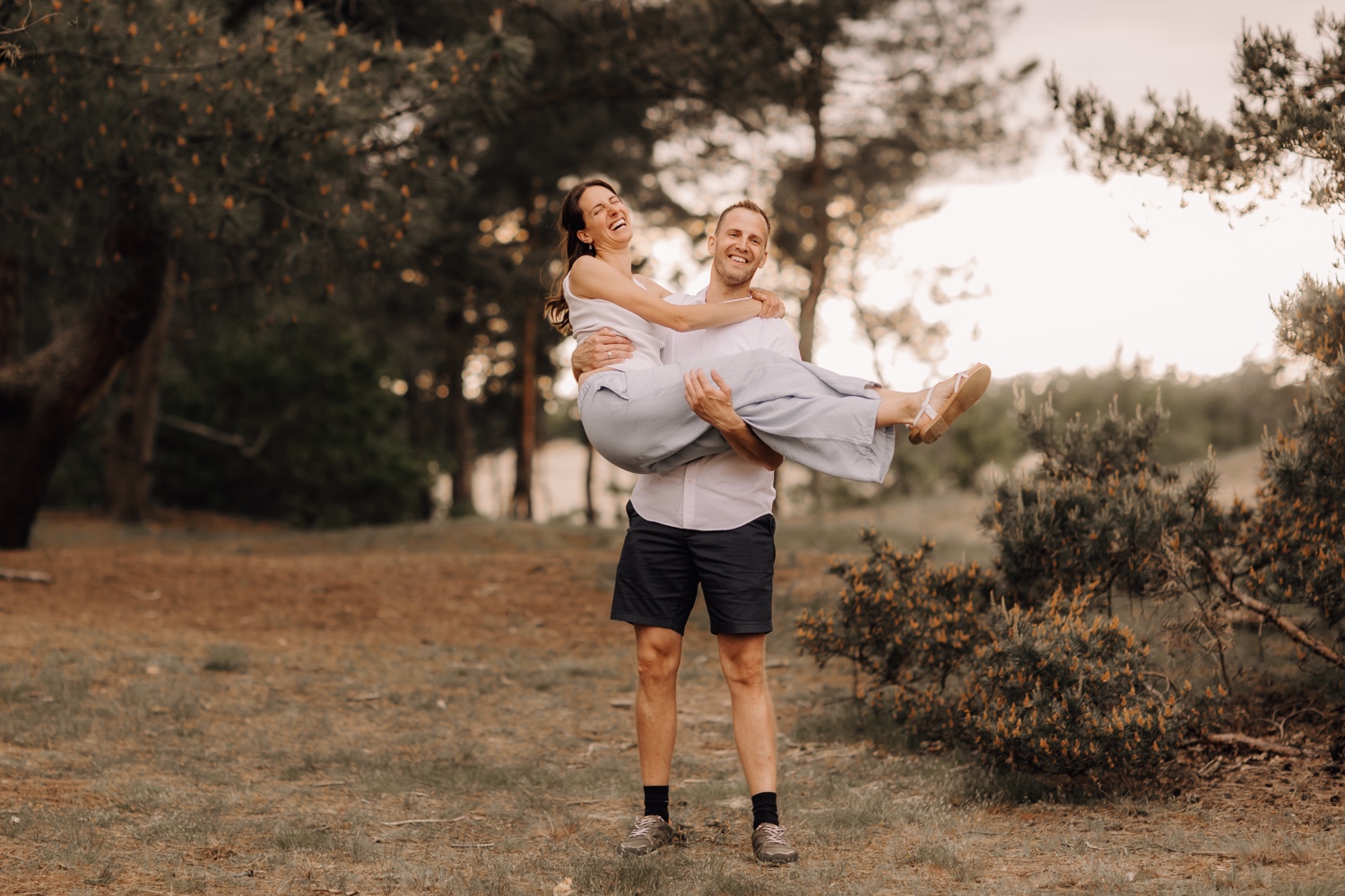 gezinsfotograaf Limburg - broer heft zus in de lucht voor ludieke foto