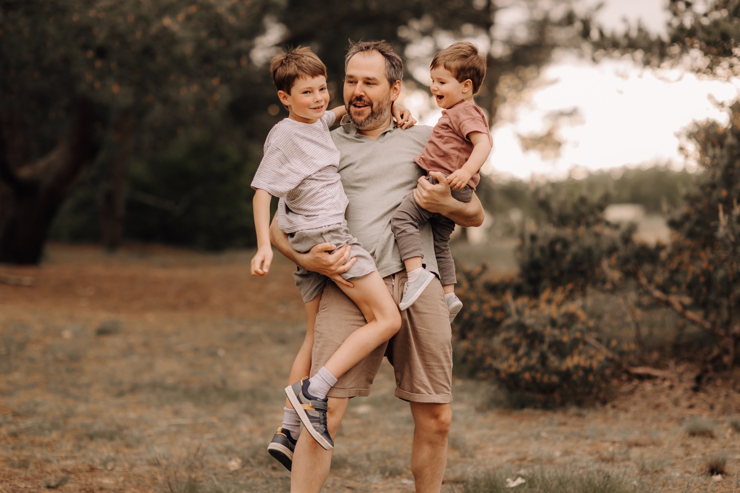 gezinsfotograaf Limburg - vader poseert met zijn zonen in Hechtel