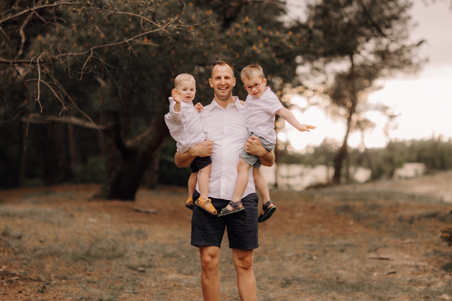 gezinsfotograaf Limburg - vader poseert met zijn zoontjes in Hechtel