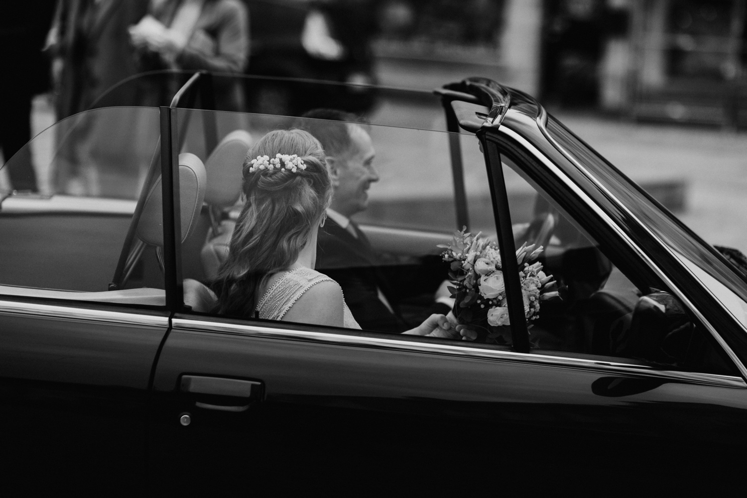 Huwelijksfotograaf Limburg - bruid en vader rijden in de bruidswagen