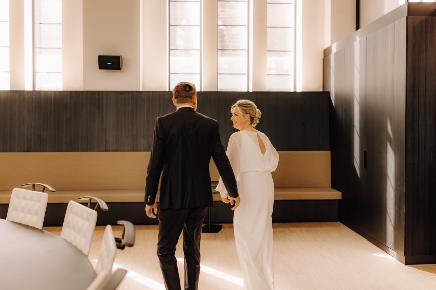 Huwelijksfotograaf Limburg - bruidspaar lacht naar elkaar tijdens intrede gemeentehuis Beringen
