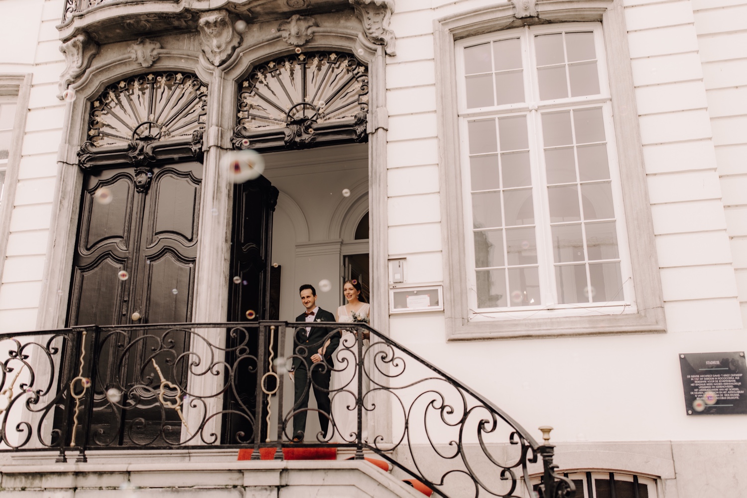 Huwelijksfotograaf Limburg - bruidspaar wandelt gemeentehuis uit