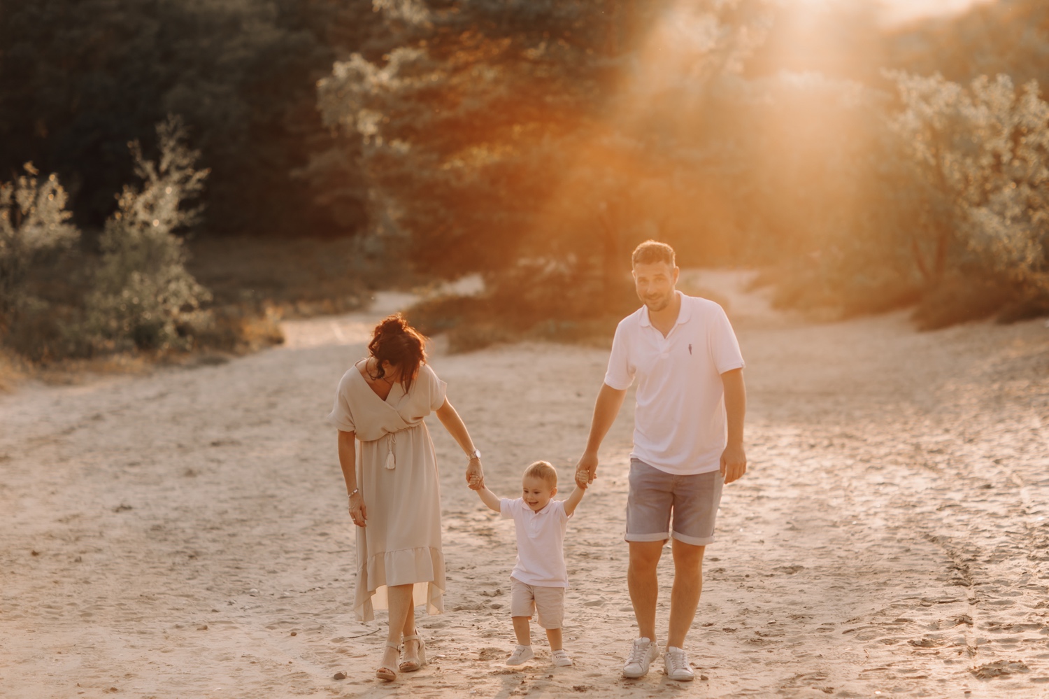 gezin wandelt door het zand bij zonsondergang