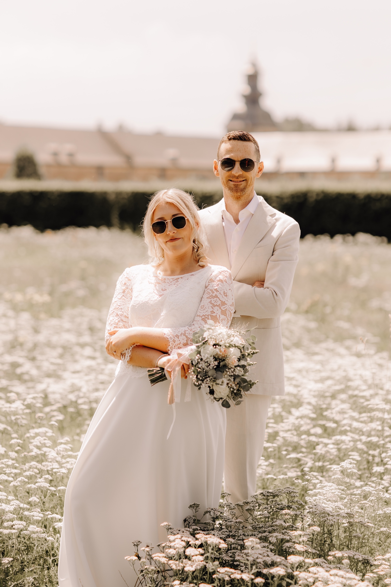 bruidspaar poseert tussen de bloemetjes op het domein van Herkenrode met hun zonnebril
