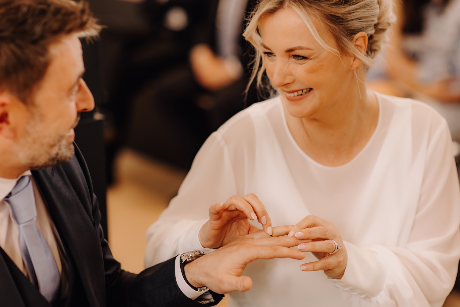 Huwelijksfotograaf Limburg - bruid lacht terwijl ze ring om vinger bruidegom doet