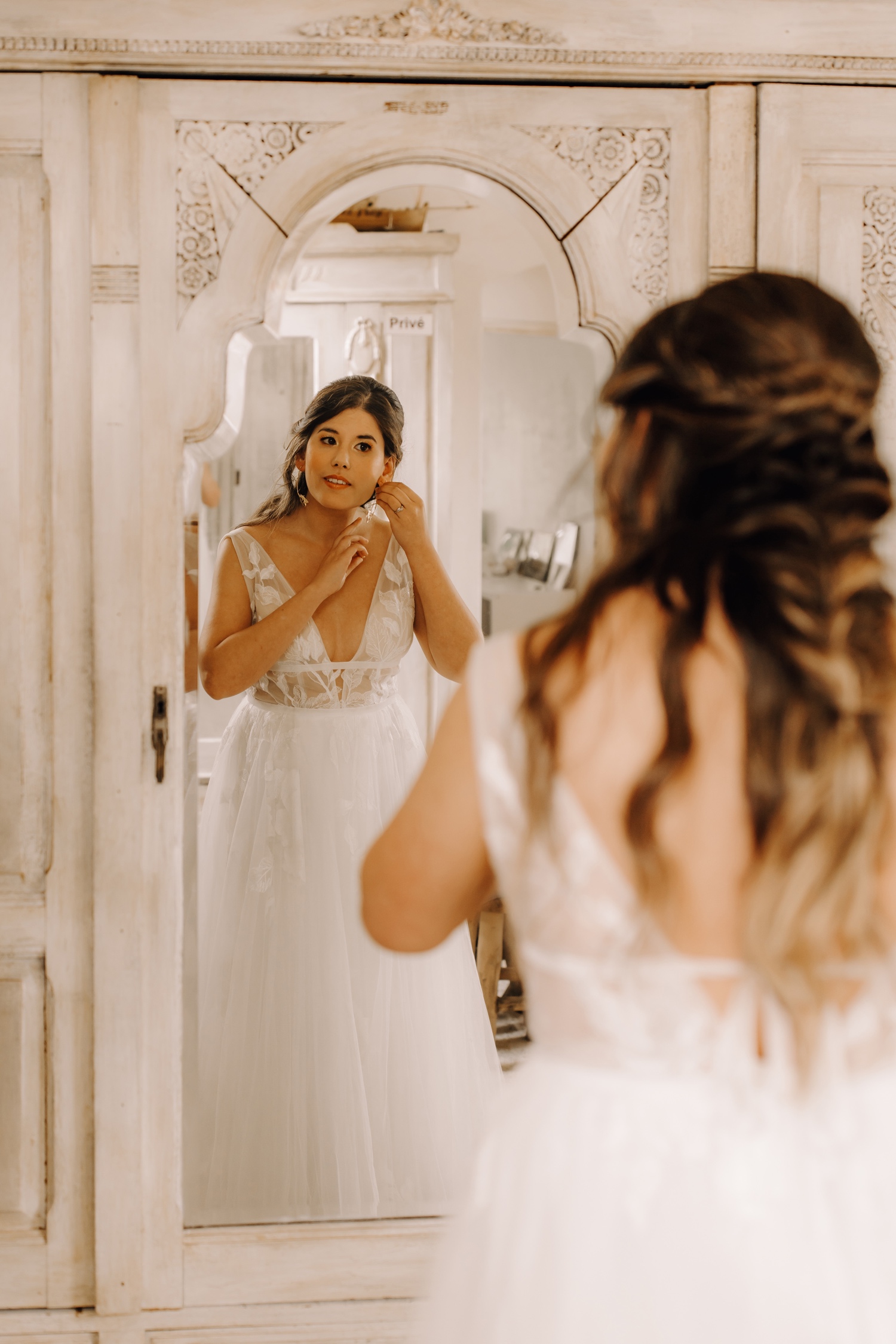 Huwelijksfotograaf Limburg - bruid doet oorbellen aan voor de spiegel
