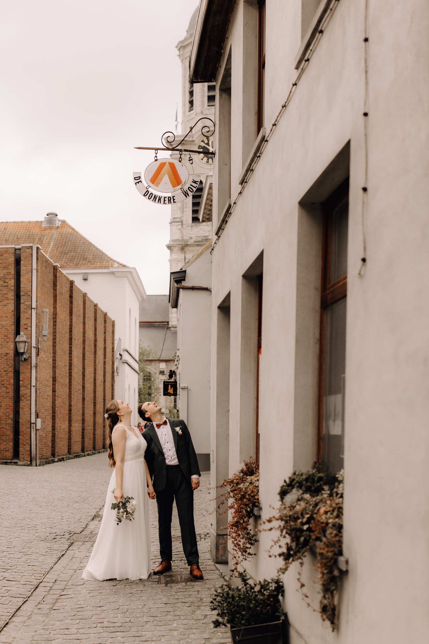 Huwelijksfotograaf Limburg - bruidspaar poseert voor hun favoriete café in Lokeren