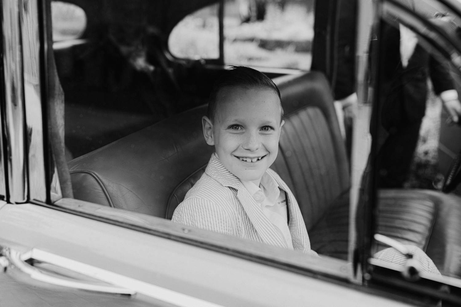 zwart-wit foto van zoon in oldtimer bruidswagen