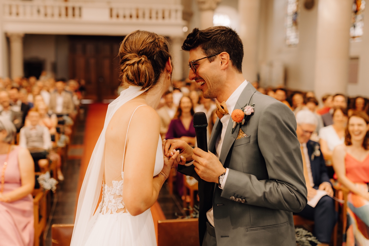 bruidspaar lacht tijdens geloften in de kerk