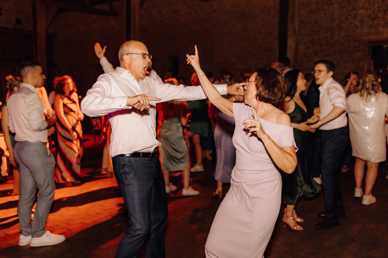 mama en stiefpapa van bruid dansen stevig op de dansvloer