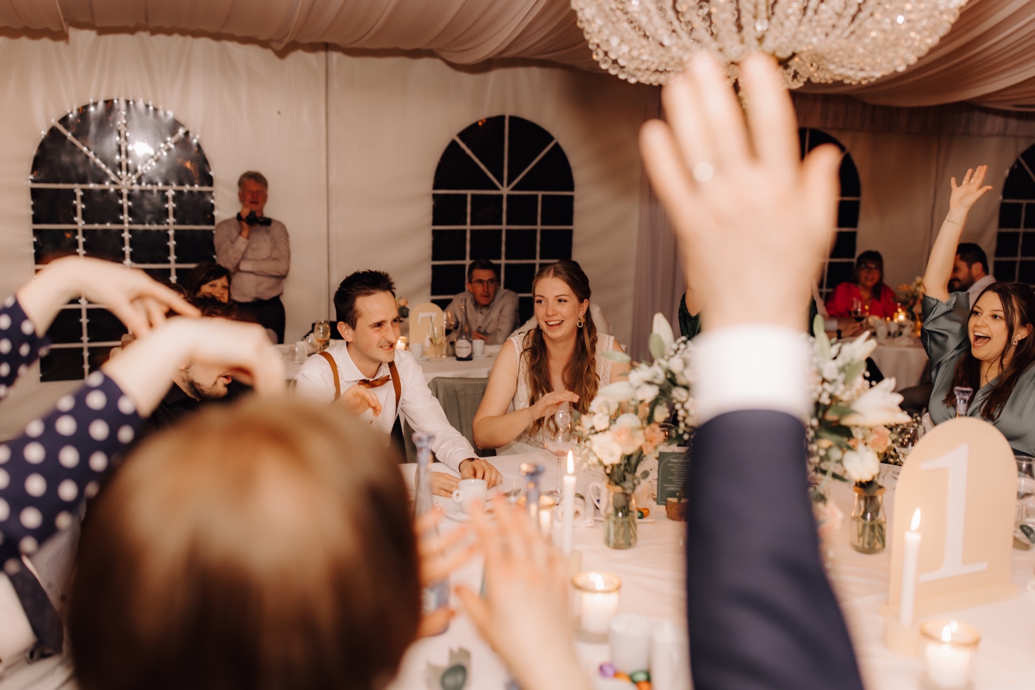 Huwelijksfotograaf Limburg - gasten steken handen in de lucht
