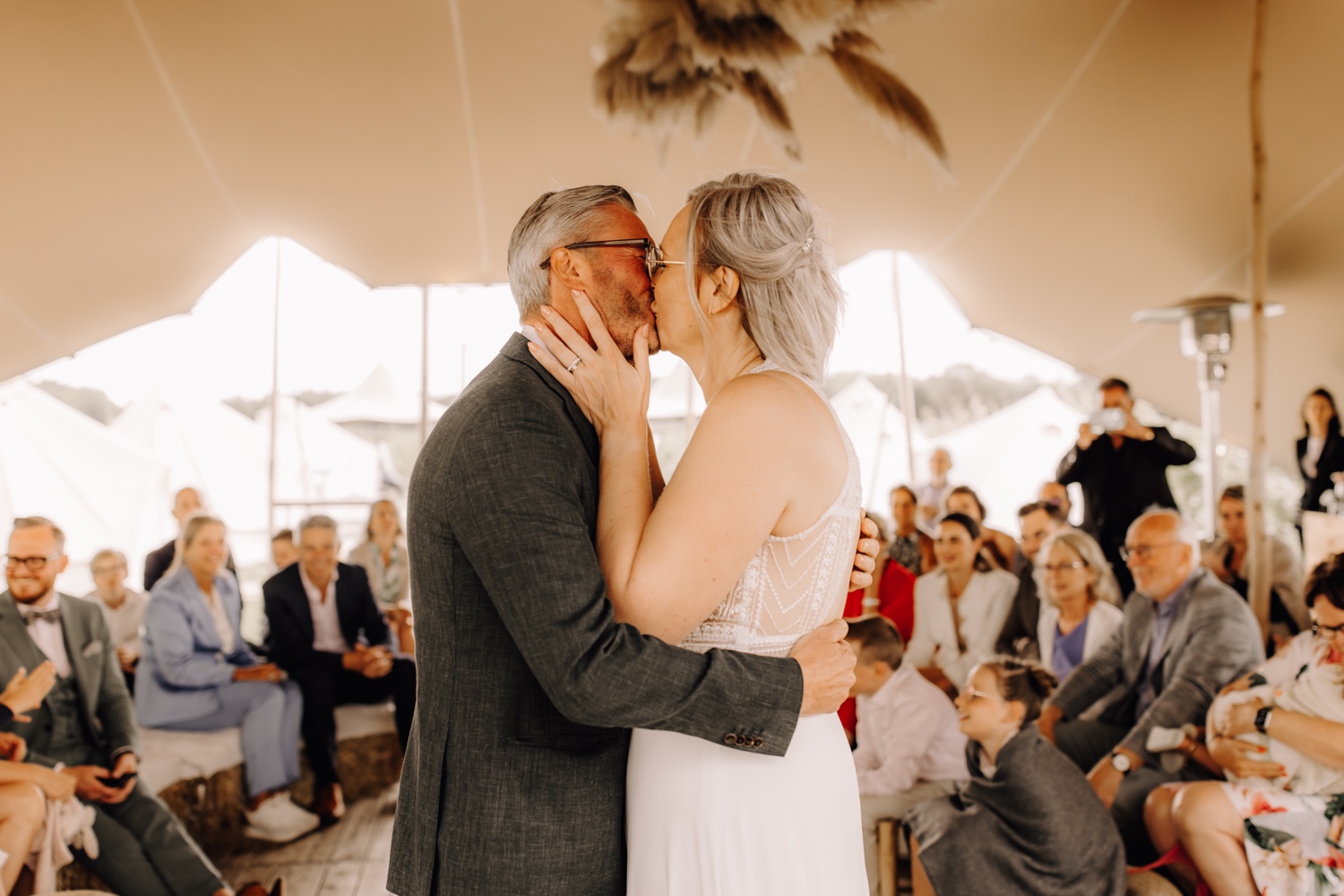 bruidspaar kust elkaar na ja-woord tijdens ceremonie