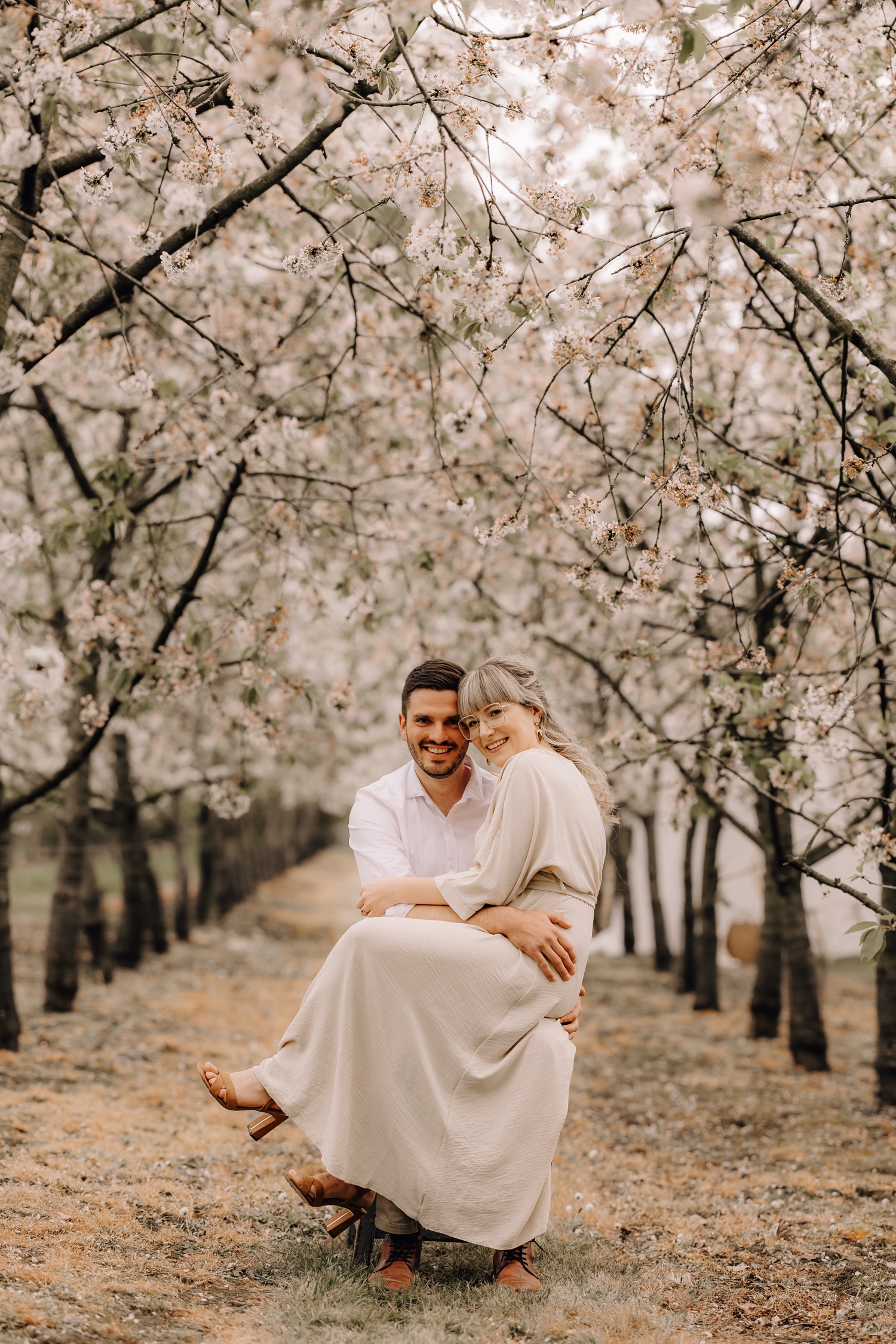 Huwelijksfotograaf Limburg - verlooft koppel poseert tussen de bloesems